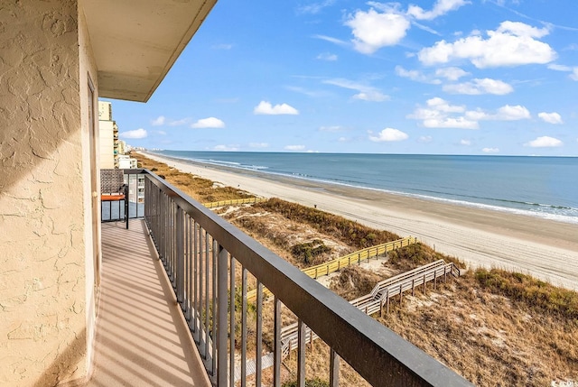 balcony featuring a water view and a beach view