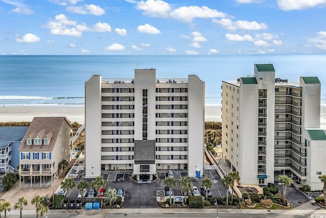 view of building exterior with a water view and a beach view