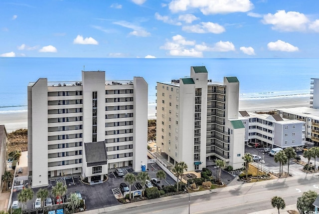 view of building exterior with a water view and a view of the beach