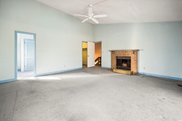 unfurnished living room with carpet, ceiling fan, high vaulted ceiling, and a brick fireplace