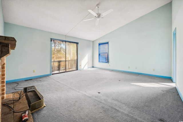 unfurnished living room with ceiling fan, a fireplace, carpet, and vaulted ceiling