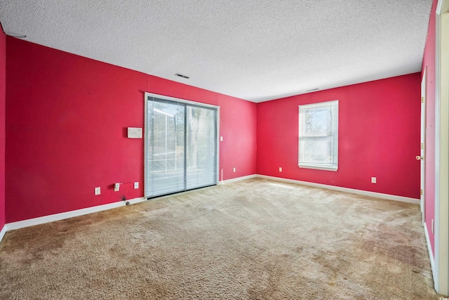 carpeted empty room with a textured ceiling