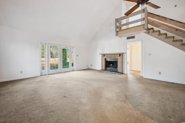 unfurnished living room with ceiling fan, carpet floors, a fireplace, and high vaulted ceiling