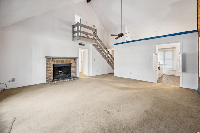 unfurnished living room with carpet, a brick fireplace, ceiling fan, beam ceiling, and high vaulted ceiling