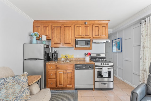 kitchen featuring appliances with stainless steel finishes, light stone counters, ornamental molding, sink, and light tile patterned flooring