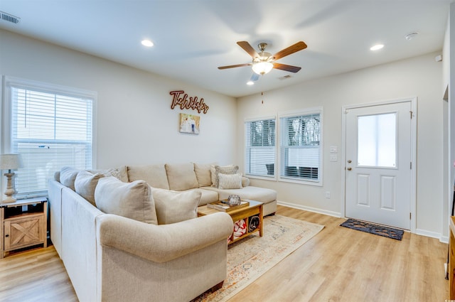 living room featuring ceiling fan, plenty of natural light, and light hardwood / wood-style flooring