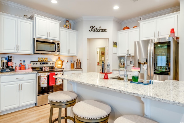 kitchen featuring backsplash, a kitchen bar, light stone countertops, stainless steel appliances, and white cabinets