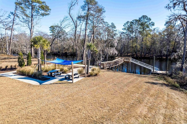 dock area with a water view and a lawn