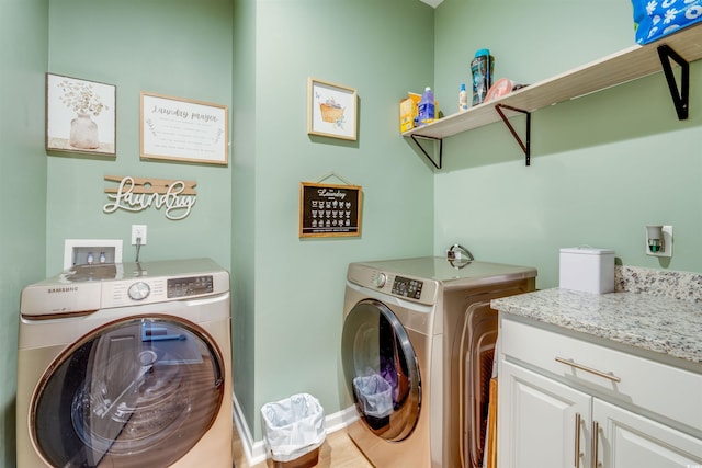 washroom featuring cabinets and washer and clothes dryer