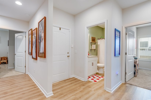 corridor with light hardwood / wood-style floors