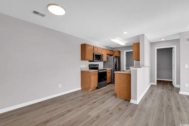 kitchen with stainless steel appliances and light hardwood / wood-style flooring