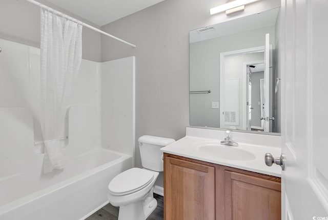 full bathroom featuring hardwood / wood-style floors, vanity, toilet, and shower / tub combo