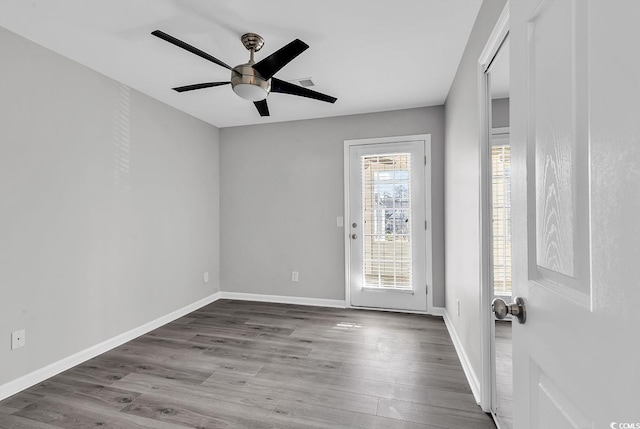 empty room with ceiling fan, light hardwood / wood-style flooring, and a healthy amount of sunlight