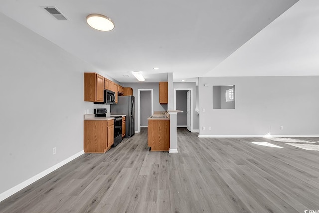 kitchen with light hardwood / wood-style flooring, stainless steel refrigerator, and black / electric stove