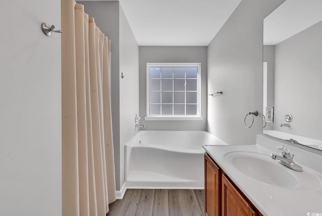 bathroom with a tub, vanity, and hardwood / wood-style flooring