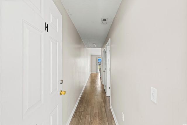 hallway with hardwood / wood-style flooring