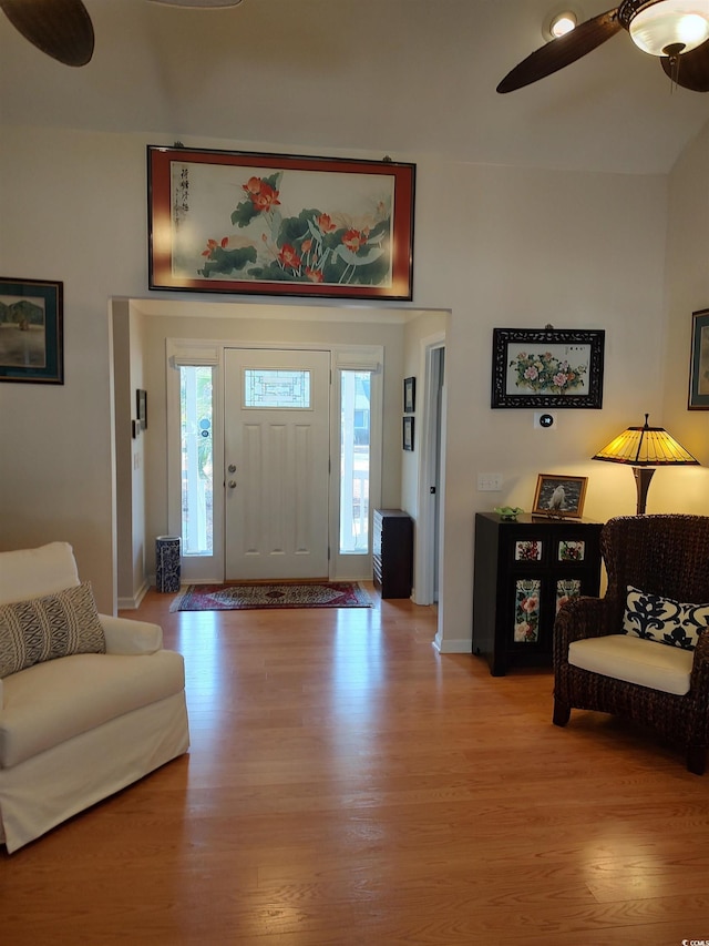 foyer with ceiling fan, light wood-style flooring, and baseboards