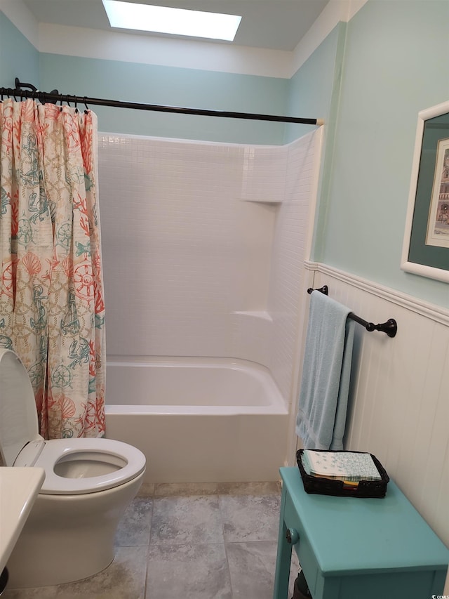 bathroom featuring toilet, shower / bathtub combination with curtain, and a skylight