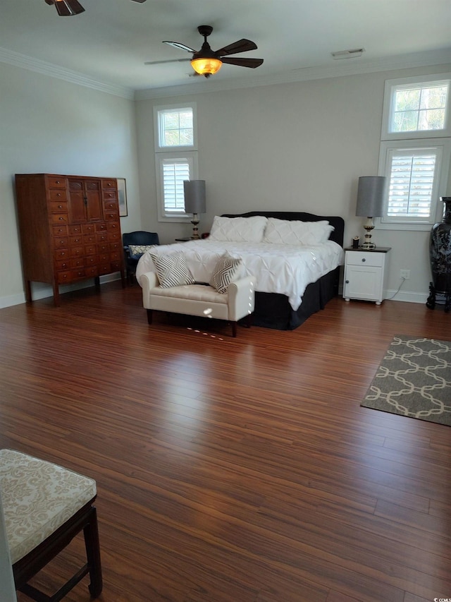 bedroom with ornamental molding, multiple windows, dark wood finished floors, and visible vents