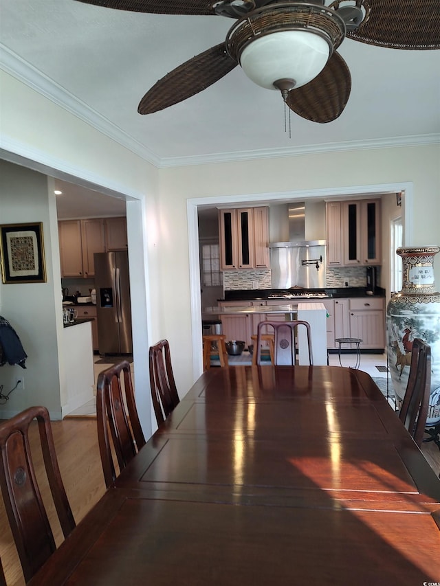 dining area with light wood-type flooring, ceiling fan, and crown molding