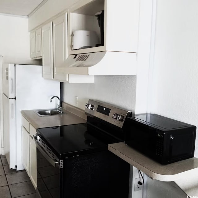 kitchen with sink, dark tile patterned floors, white cabinetry, range hood, and stainless steel range with electric cooktop