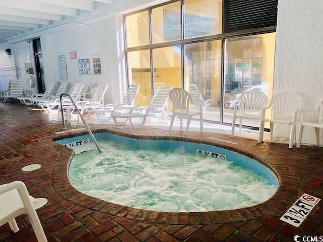 view of swimming pool featuring an indoor hot tub