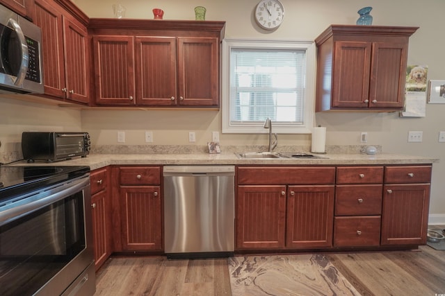 141 Baylee Cir, Galivants Ferry, SC 29544 - kitchen featuring stainless steel appliances, light wood finished floors, a sink, and dark brown cabinets