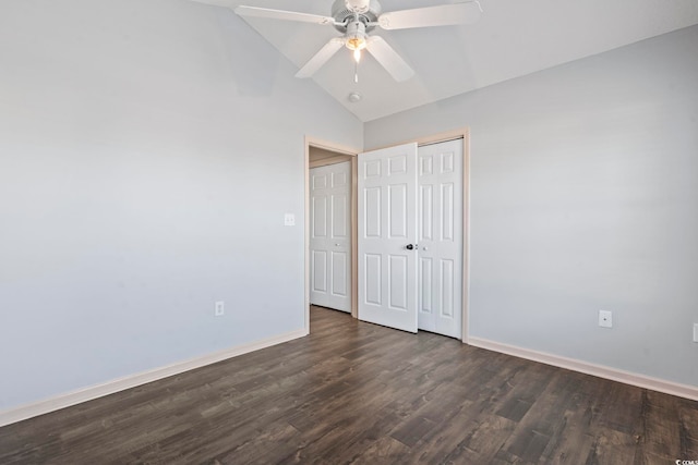 unfurnished bedroom with ceiling fan, a closet, dark wood-type flooring, and lofted ceiling