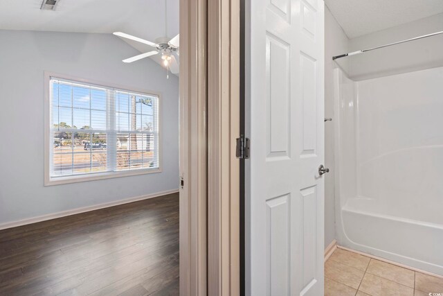 bathroom featuring ceiling fan, shower / bathtub combination, and tile patterned floors