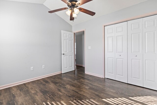 unfurnished bedroom featuring lofted ceiling, ceiling fan, a closet, and dark wood-type flooring