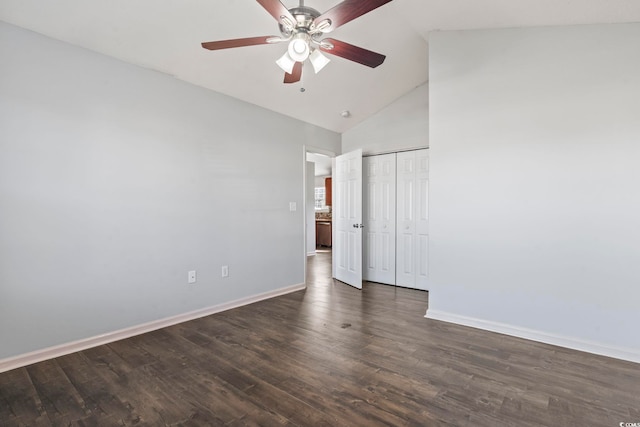 unfurnished bedroom featuring ceiling fan, a closet, dark hardwood / wood-style floors, and high vaulted ceiling