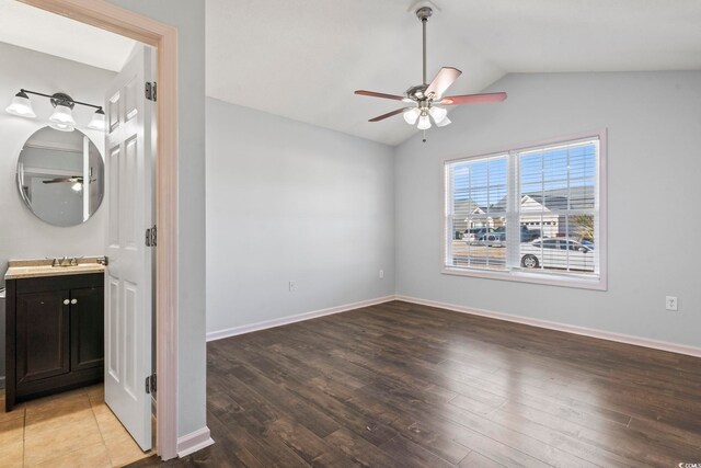 interior space featuring ensuite bathroom, hardwood / wood-style floors, ceiling fan, vaulted ceiling, and sink