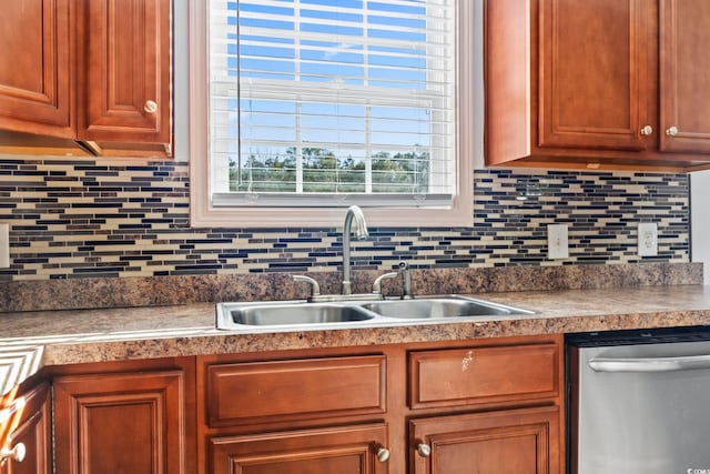 kitchen with stainless steel dishwasher, sink, and tasteful backsplash