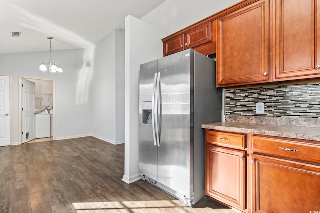 kitchen featuring stainless steel refrigerator with ice dispenser, decorative backsplash, decorative light fixtures, vaulted ceiling, and a chandelier