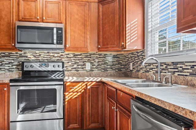 kitchen with backsplash, appliances with stainless steel finishes, and sink