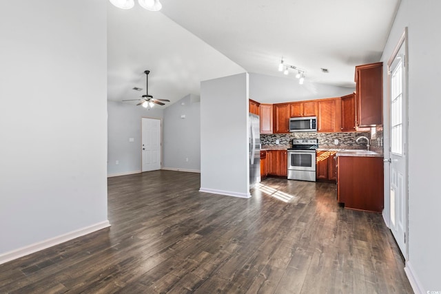 kitchen with appliances with stainless steel finishes, dark hardwood / wood-style flooring, backsplash, vaulted ceiling, and ceiling fan