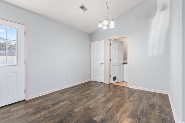 interior space with dark wood-type flooring, lofted ceiling, and an inviting chandelier