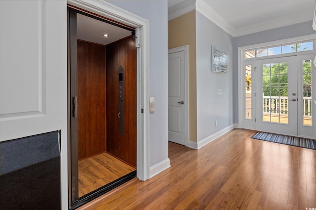 interior space featuring elevator, ornamental molding, and light hardwood / wood-style floors