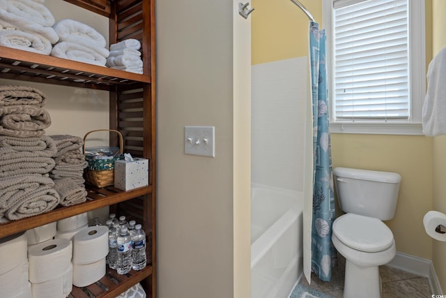 bathroom featuring shower / bathtub combination with curtain, tile patterned floors, and toilet