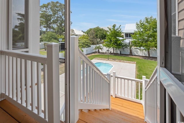 wooden terrace featuring a yard, a fenced in pool, and a patio