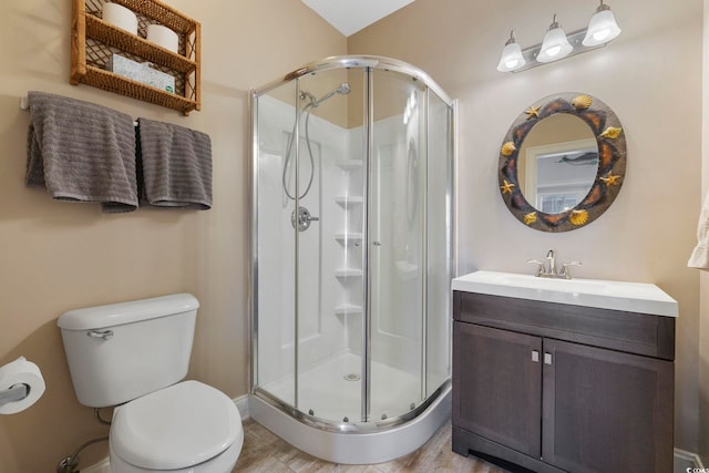 bathroom with vanity, a shower with shower door, and toilet