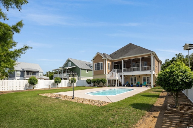 rear view of property with a yard, a fenced in pool, a patio area, and a sunroom