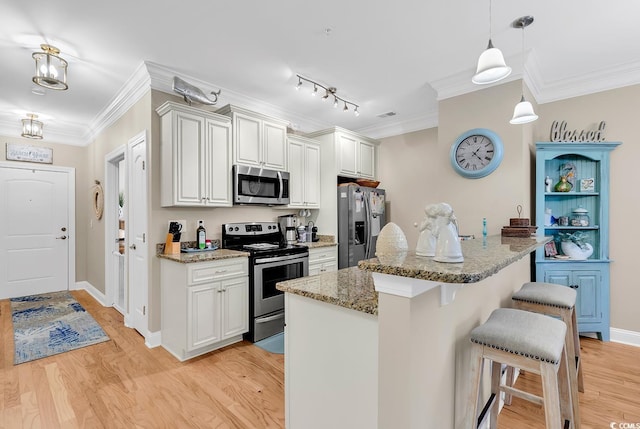 kitchen with white cabinetry, appliances with stainless steel finishes, and light stone countertops