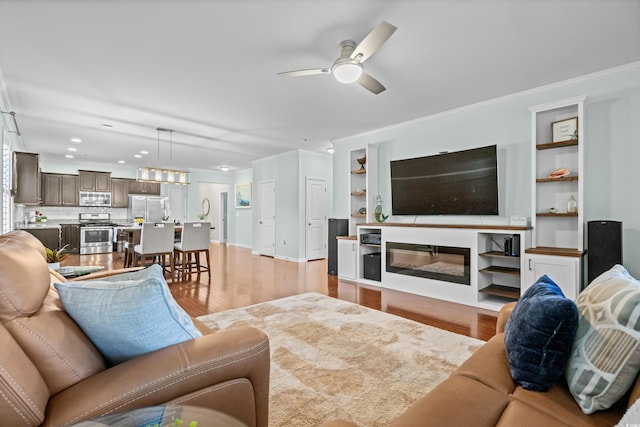 3716 Mackevans Ct, Myrtle Beach, SC 29579 - living room with light wood-type flooring, a ceiling fan, crown molding, recessed lighting, and built in shelves