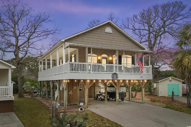 view of front facade with covered porch, a carport, and a storage unit