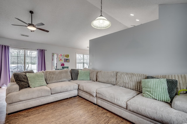 living room featuring hardwood / wood-style floors, a wealth of natural light, lofted ceiling, and ceiling fan