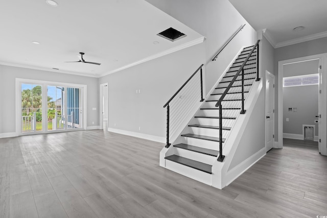 stairs with hardwood / wood-style flooring, ceiling fan, and ornamental molding