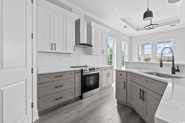 kitchen featuring wall chimney range hood, gray cabinetry, sink, and stainless steel range with electric stovetop