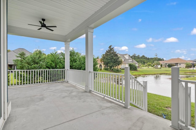 view of patio with ceiling fan, a porch, and a water view