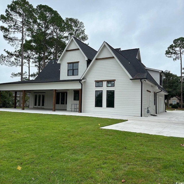 back of property featuring a lawn and a garage